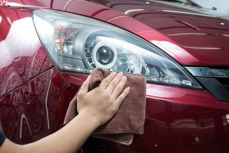 Car polishing series : Worker waxing red carの写真素材