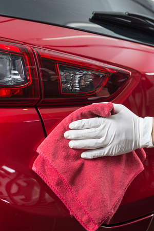 Car polishing series : Worker cleaning red carの写真素材