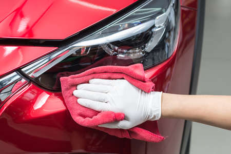 Car polishing series : Worker cleaning red carの写真素材