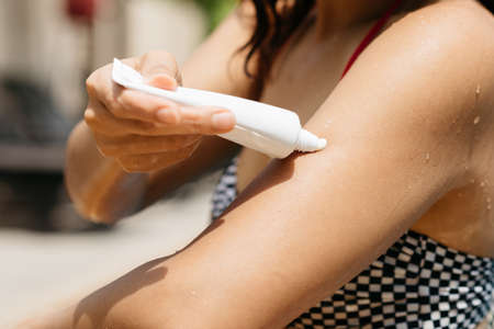 Swimming pool series : Applying sunscreen in swimming poolの写真素材