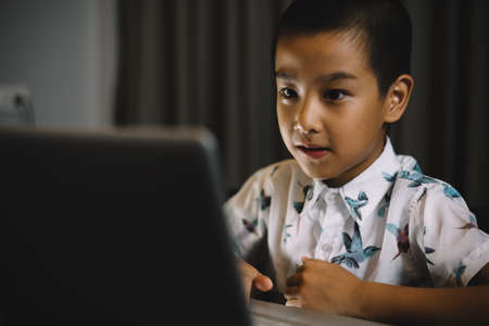 Asian family series : Boy using laptop at nightの写真素材