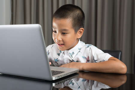 Asian family series : Boy using laptop at nightの写真素材