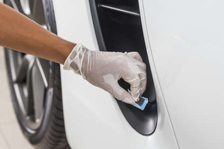 Car detailing series : Closeup of hand  coating plastic partの写真素材