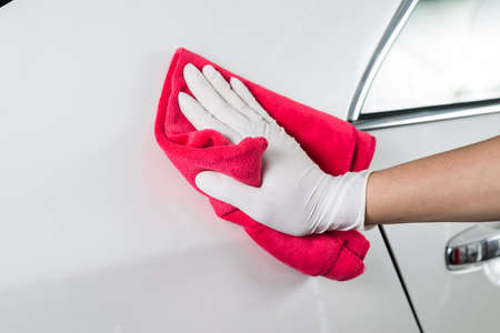 Car detailing series : Closeup of hand cleaning white carの写真素材