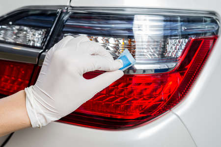Car detailing series : Closeup of hand coating white car taillightsの写真素材