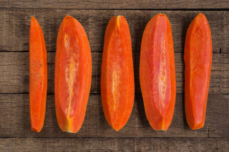 Fruits series : Five sliced papaya on wooden tableの写真素材