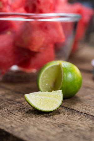 Fruits series : Sliced of lime with bowl of sliced watermelon in background