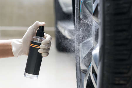 Car detailing series : Closeup of hand spray cleaning agent on car wheelの写真素材