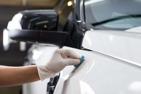 Car detailing series : Closeup of hand coating white car paint