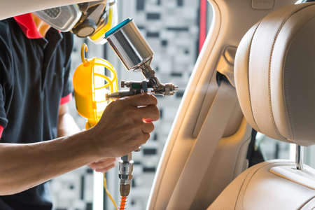 Car detailing series : Closeup of hand coating beige luxury car seatの写真素材