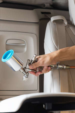 Car detailing series : Closeup of hand coating beige luxury car seatの写真素材