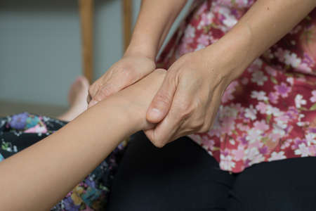 Massage series : Therapist massaging Asian woman's handの写真素材