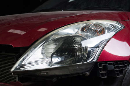 Auto body repair series : Closeup of red car headlights waiting for repaintの写真素材