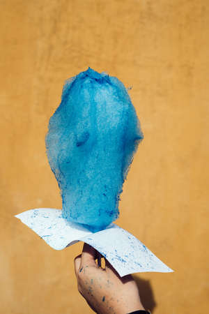 Cotton candy against yellow wall backgroundの写真素材