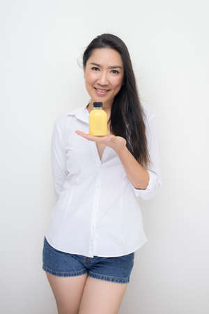 Drinks series: Asian woman holding corn milk bottle against white backgroundの写真素材
