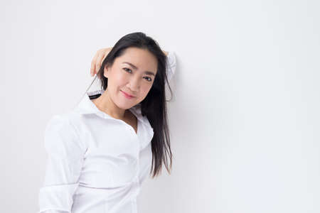 Happy Asian woman standing against white background, closeupの写真素材