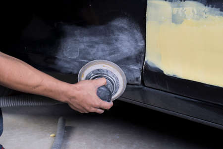 Auto body repair series: Closeup of mechanic sanding car door