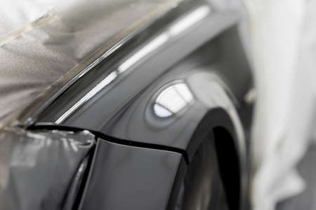 Auto body repair series: Black car being paint in paint boothの写真素材