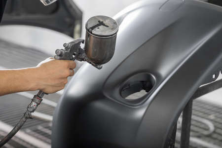 Auto body repair series: Painting car bumper in paint boothの写真素材