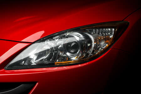 Car detailing series: Closeup of red car headlightの写真素材