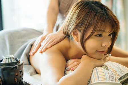 Aromatherapy massage series: Asian woman being massaged by therapistの写真素材