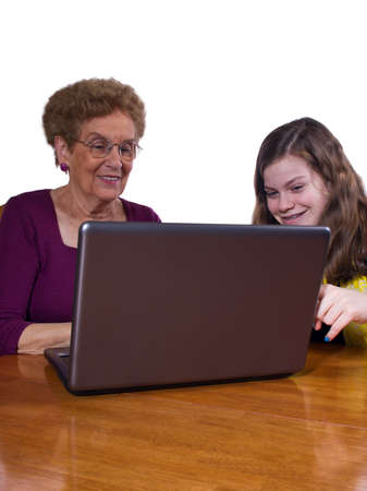 teen girl teaching grandmother to use a laptopの写真素材