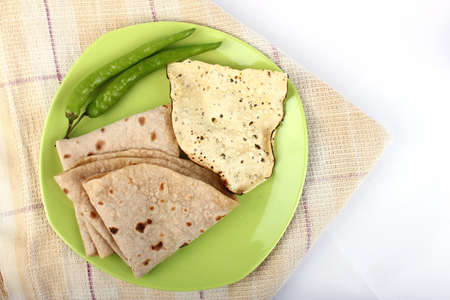 Indian roti and green fried vegetable on white background