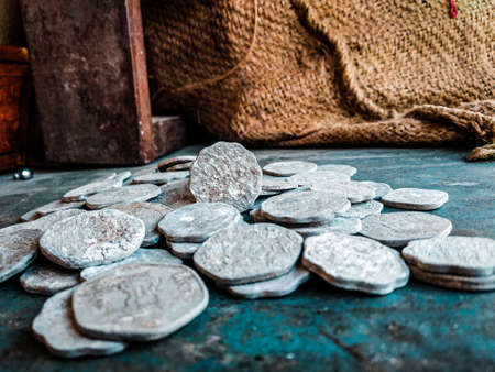 Ancient silver coins on the table in the kitchen. Selective focus.