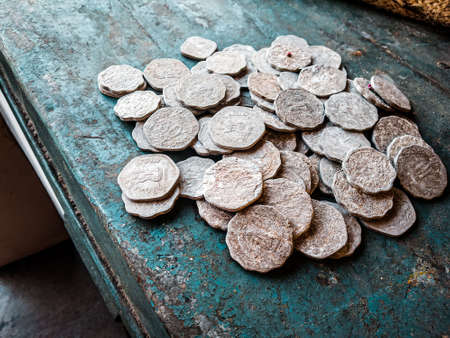 Ancient coins of the Roman Empire on an old turquoise tableの写真素材