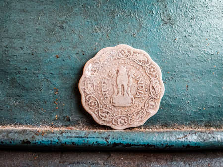 Ancient coin on a turquoise background. The concept of luck and prosperity.の写真素材
