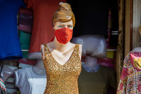 Female Mannequin with mask on face. Shops are reopening after lock down restrictions due to the covid-19 pandemic, back to normal life with few safety measure.の写真素材