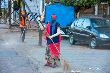 Jodhpur, Rajashtbn, India. 30 March 2020: A woman sweeping the city road in the morning manually with a traditional broom.Coronavirus, covid-19 situation.のeditorial素材