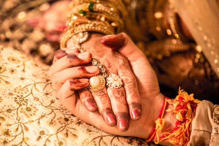 Young married couple holding hands, indian ceremony wedding day, promise to be together for lifetime.の写真素材