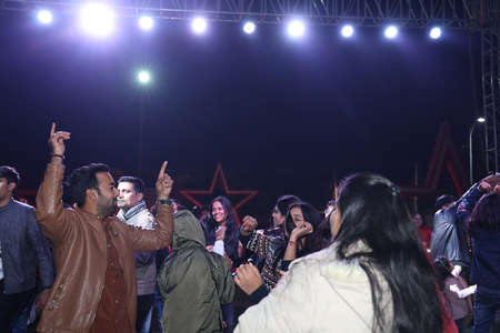 Group of joyful people dancing on a crowded dance floor at a ceremony or event at night, group of...
