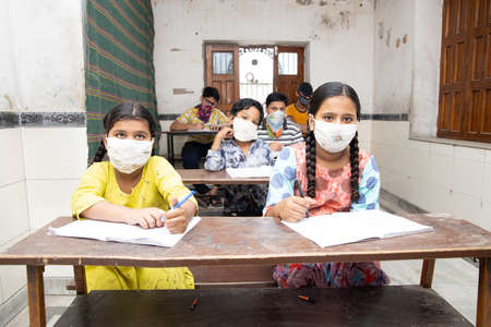 Indian Students Studying In Classroom Wearing Mask And Social Distancing, school reopen during covid19 pandemicのeditorial素材