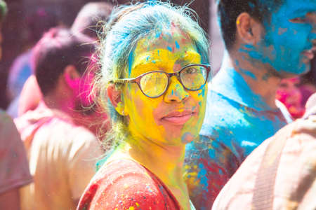 Jodhpur, rajastha, india - March 20, 2020: Young indian woman face covered with colored powder, celebrating holi festival, closeup. looking at cameraのeditorial素材