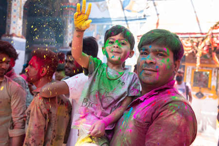 Jodhpur, rajastha, india - March 20, 2020: Young indian father and son celebrating holi festival, closeup of face covered with colored powder.のeditorial素材