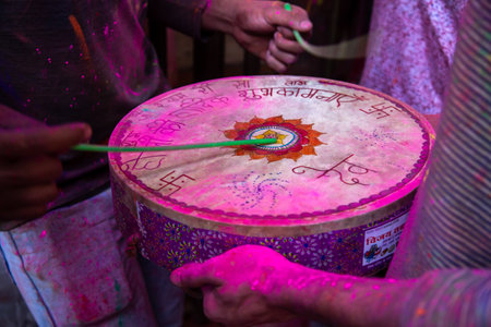 Jodhpur, rajastha, india - March 20, 2020: closeup of people hand playing indian drum with sticks during holi festival, covered with color powder, background..のeditorial素材