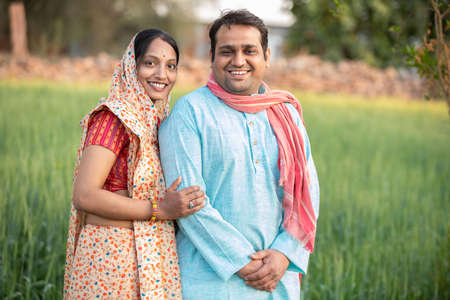 Happy indian rural farmer couple in agricultural field.の写真素材