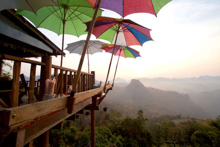 Noodle shop with sitting area with mountain view and mist. Featured with colorful umbrellas that help to protect the sun.の写真素材