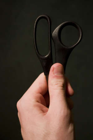 Hand Holding Black Scissors against a background