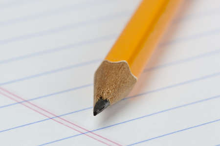 A yellow pencil on notebook paperの写真素材