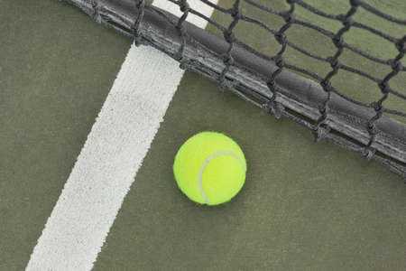 A yellow tennis ball on a courtの写真素材