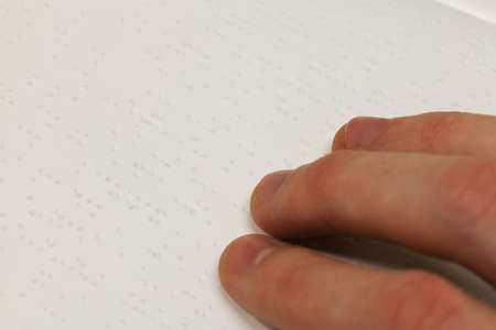 A hand on a braille bookの写真素材