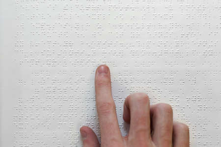 A hand on a braille bookの写真素材