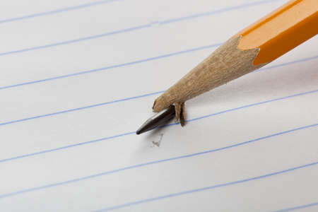 A broken yellow pencil on notebook paperの写真素材