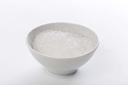 White sea salt against a white backgroundの写真素材