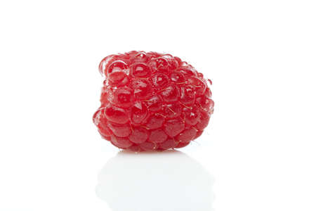 A fresh red raspberry against a white background