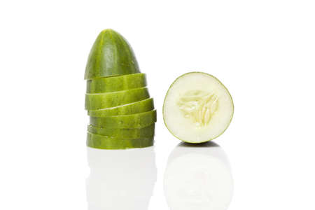 A sliced green cucumber against a white backgroundの写真素材