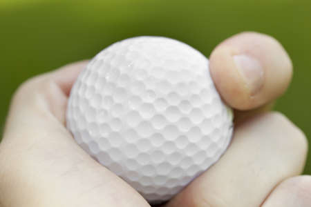 A white golf ball sitting in green grassの写真素材